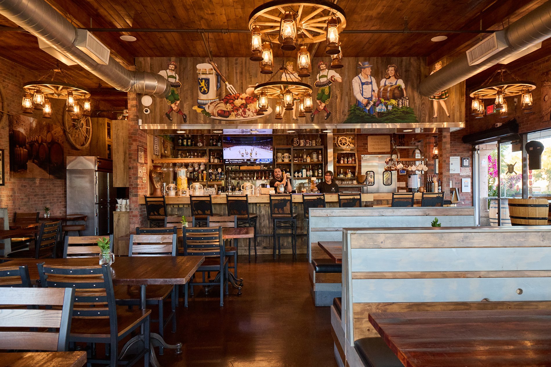 Wooden tables, lantern chandeliers, and the welcoming bar at Alps Village